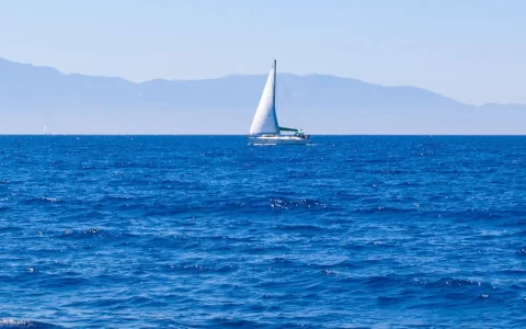 航行在蓝色大海上的白色帆船唯美风格手机壁纸